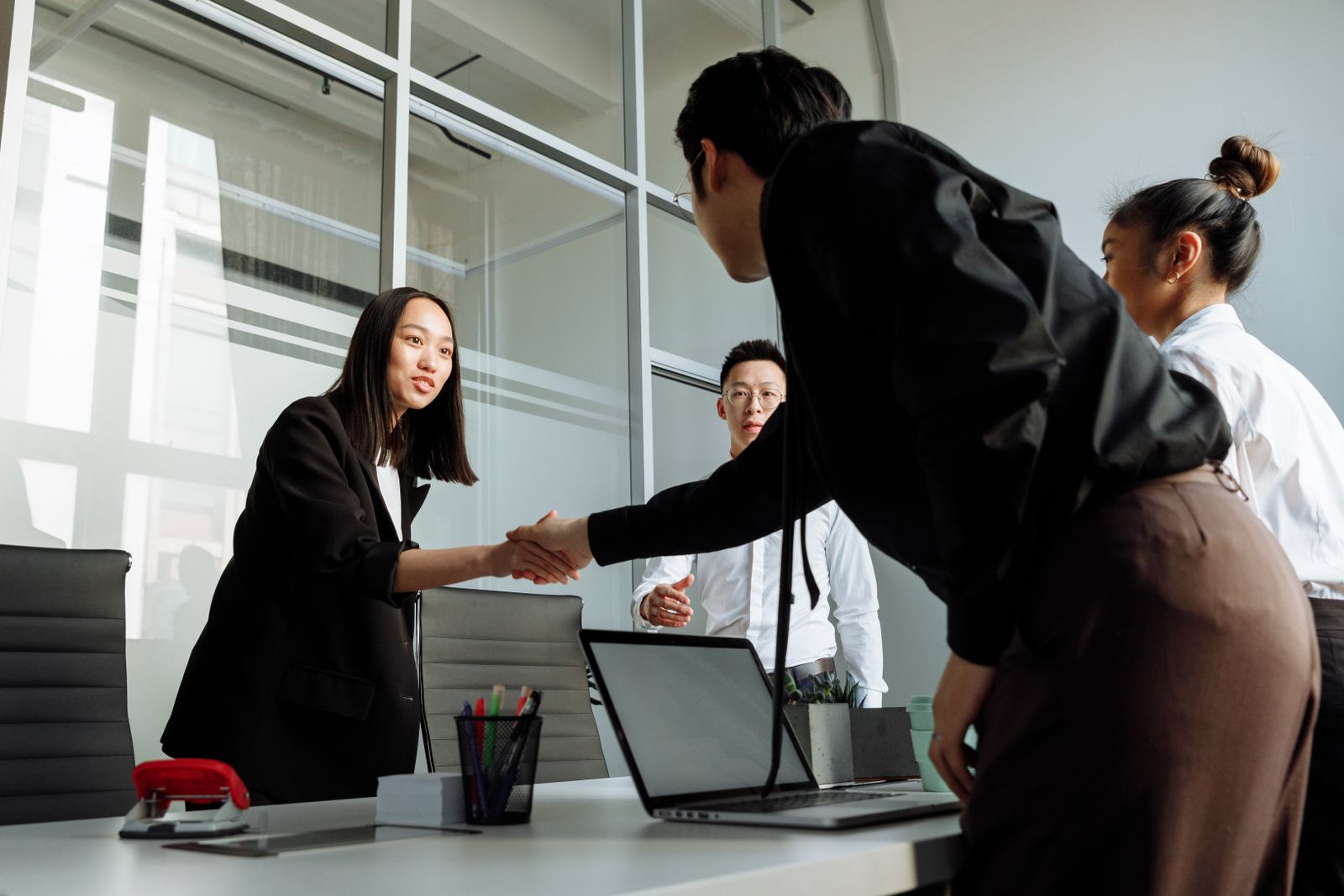 Business professionals shaking hands during a company registration consultation in Laos