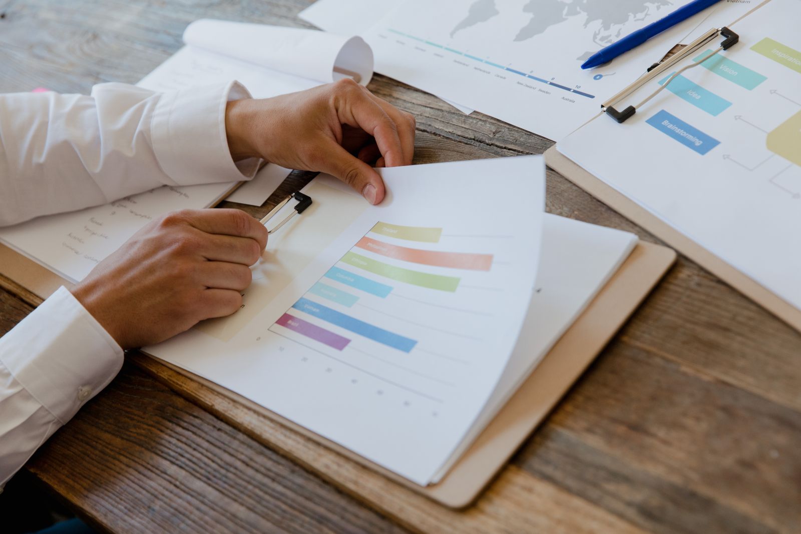 Hands reviewing an interim financial report with charts and graphs on a desk