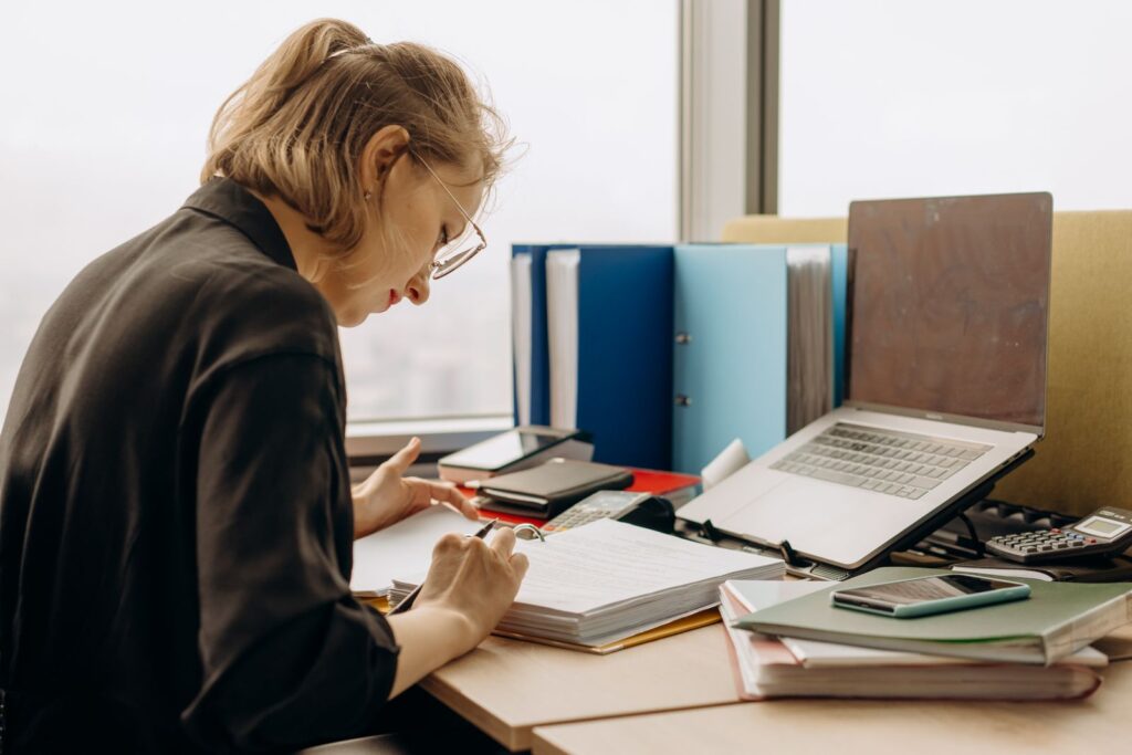 Administrator reviewing payroll and HR records at a desk